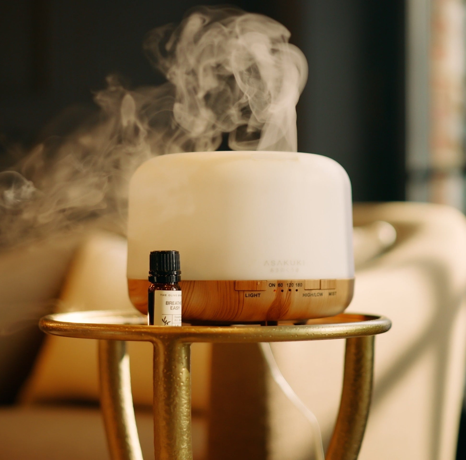 Diffuser by the 'Olive Branch' with steam rising on a table in a room setting