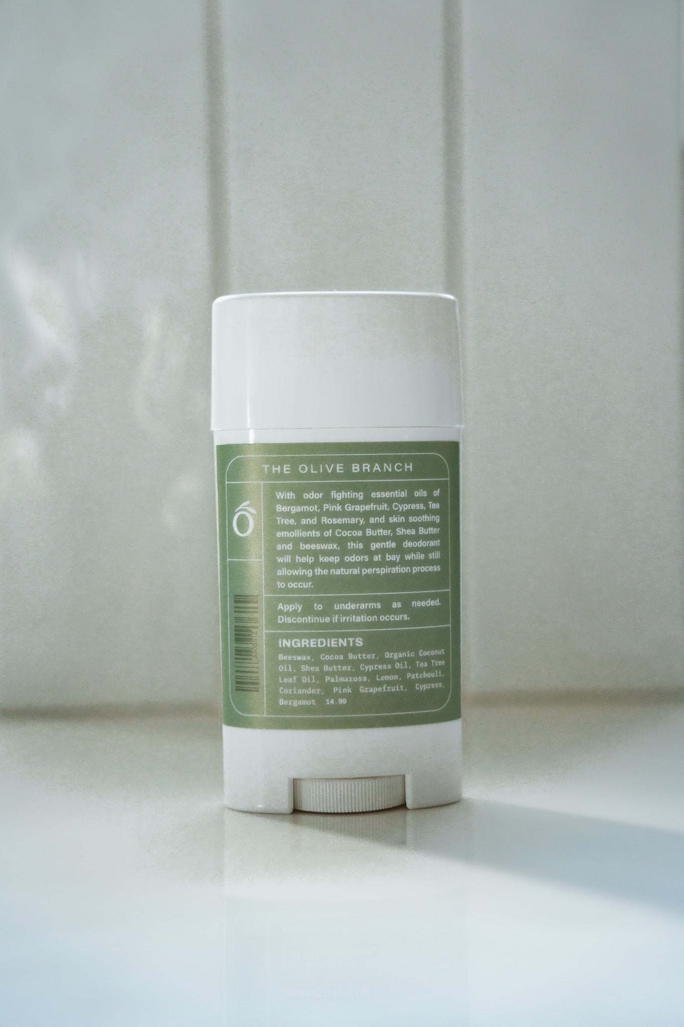 Deodorant stick with green label on a white surface