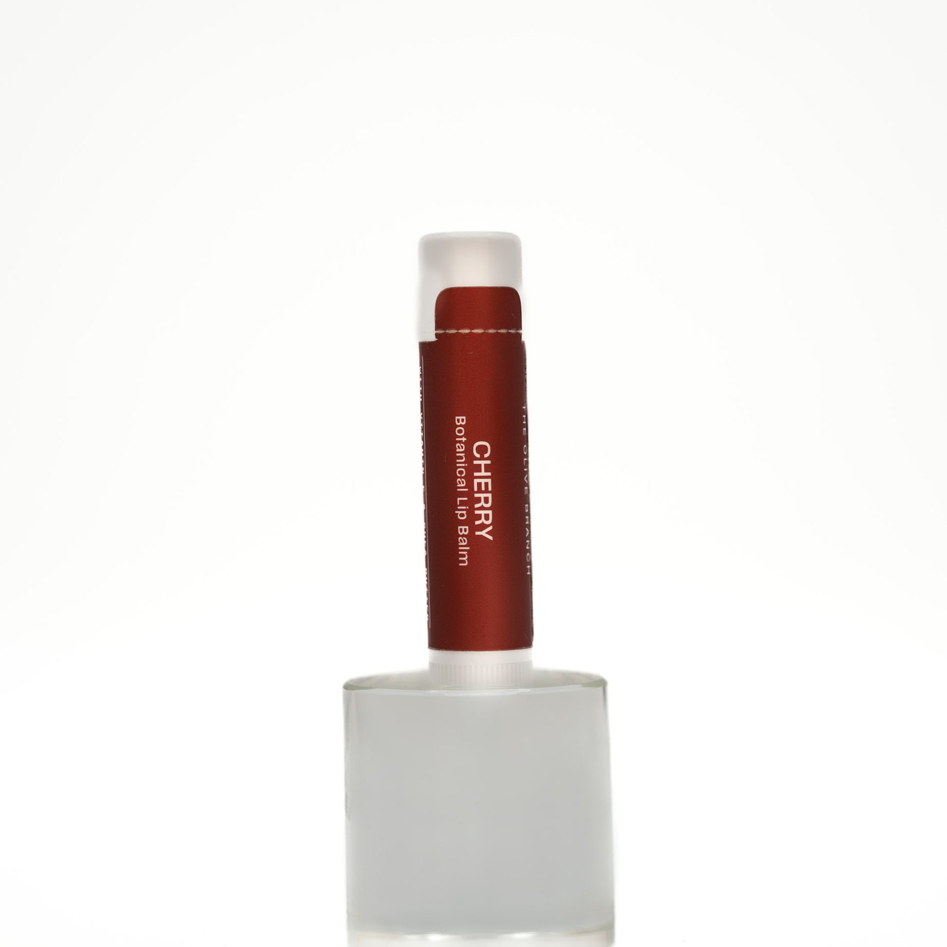 Lip balm with a red container and white cap on a white background