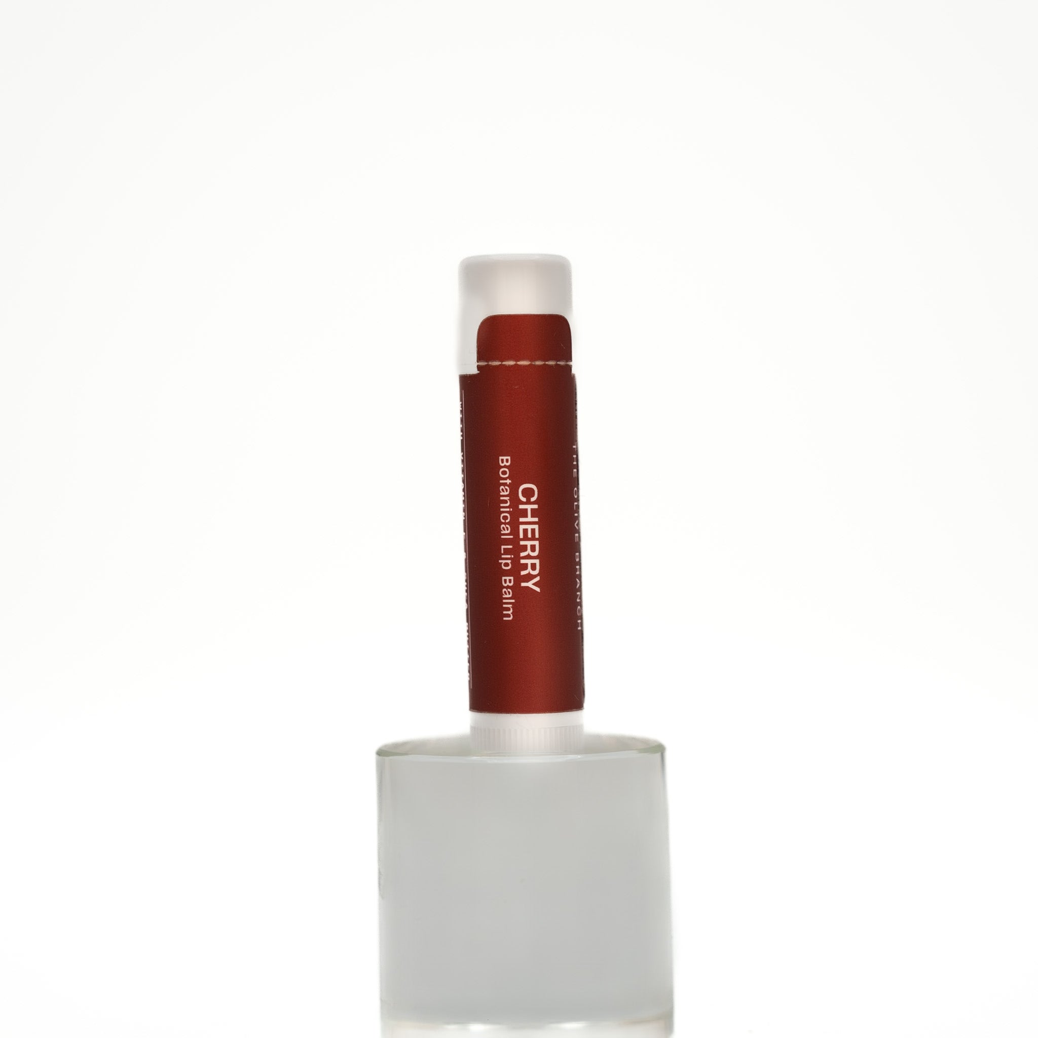 Lip balm with a red container and white cap on a white background
