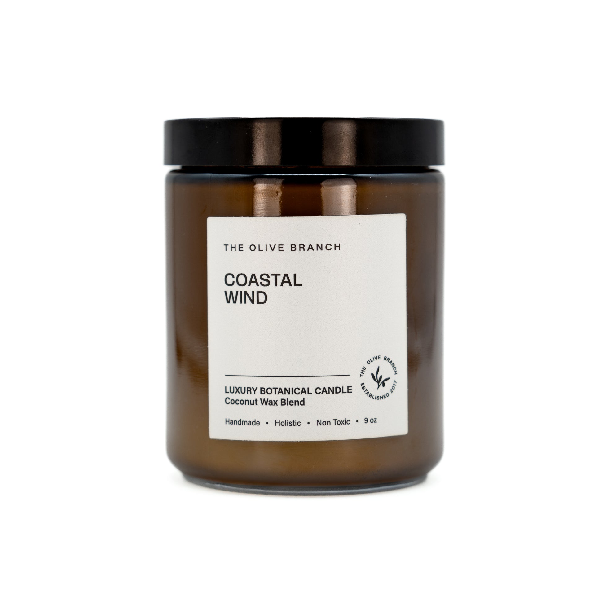 Coastal Wind candle in amber jar with black lid on a white background