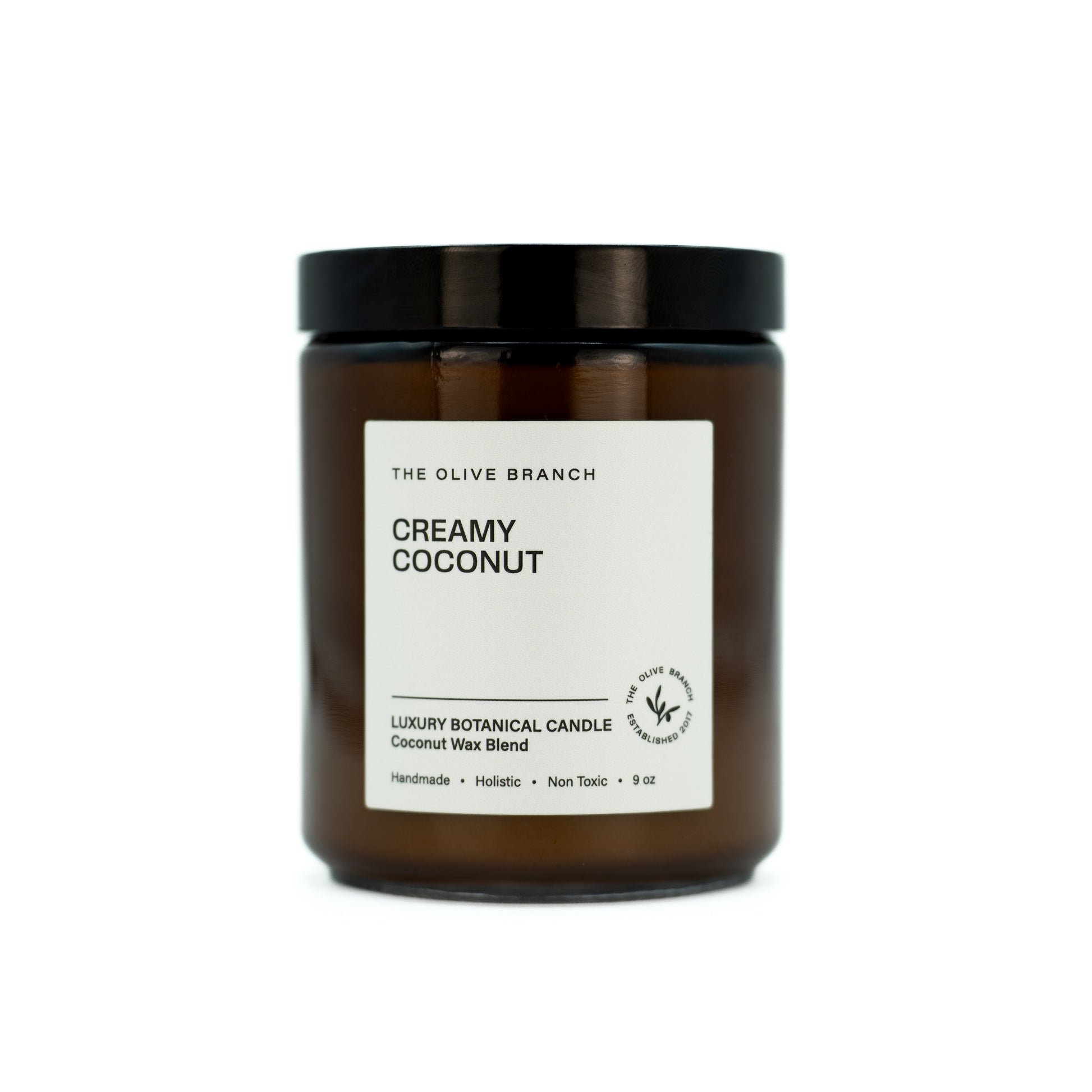 Brown candle jar 'creamy coconut' with a white label on a white background