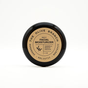 Facial moisturizer jar with 'The Olive Branch' branding on a white background