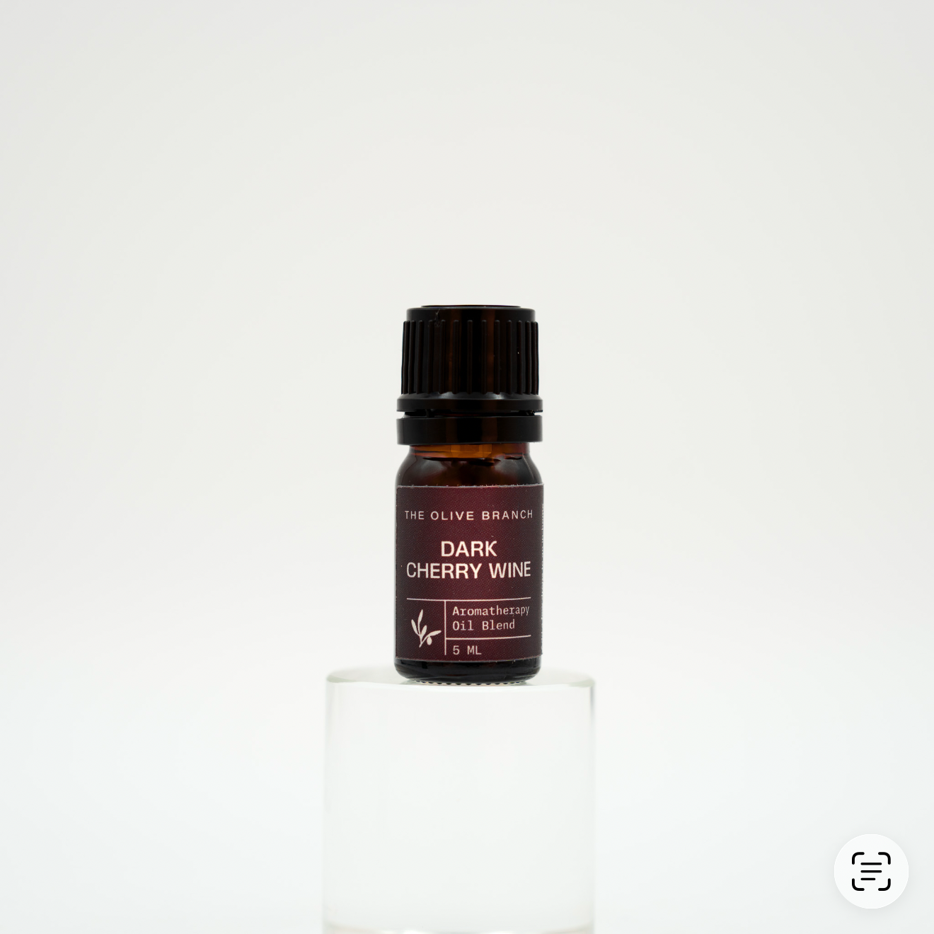 Small brown bottle of a aromatherapy oil blend with a black cap on a white background