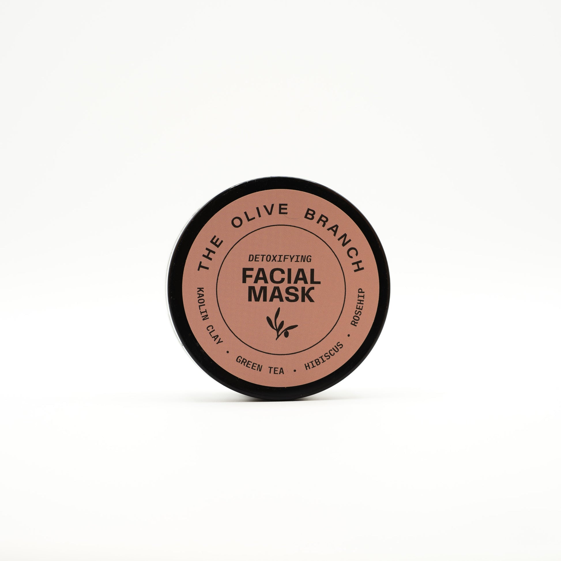 Facial mask container with 'The Olive Branch' branding on a white background