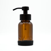 Amber glass bottle with black pump on a white background