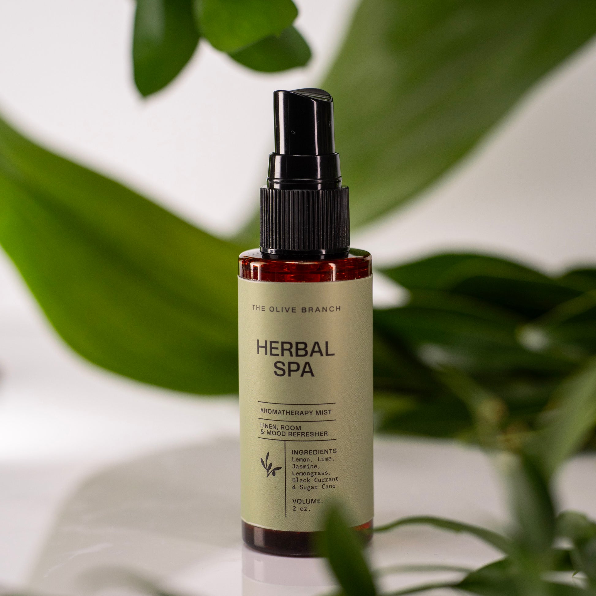 Herbal Spa aromatherapy mist bottle with green leaves in the background