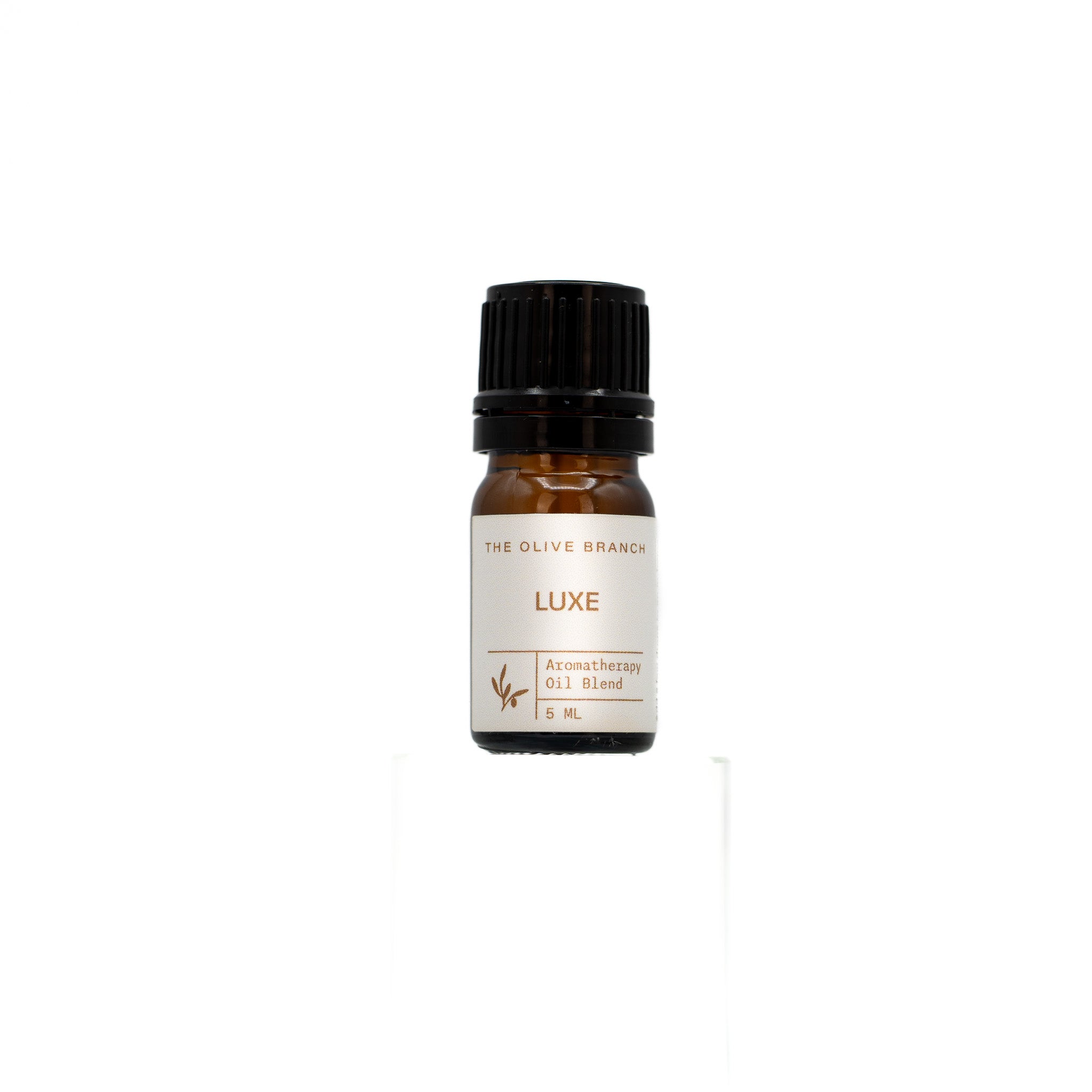 Small bottle of 'LUXE' aromatherapy oil blend by 'The Olive Branch' on a white background