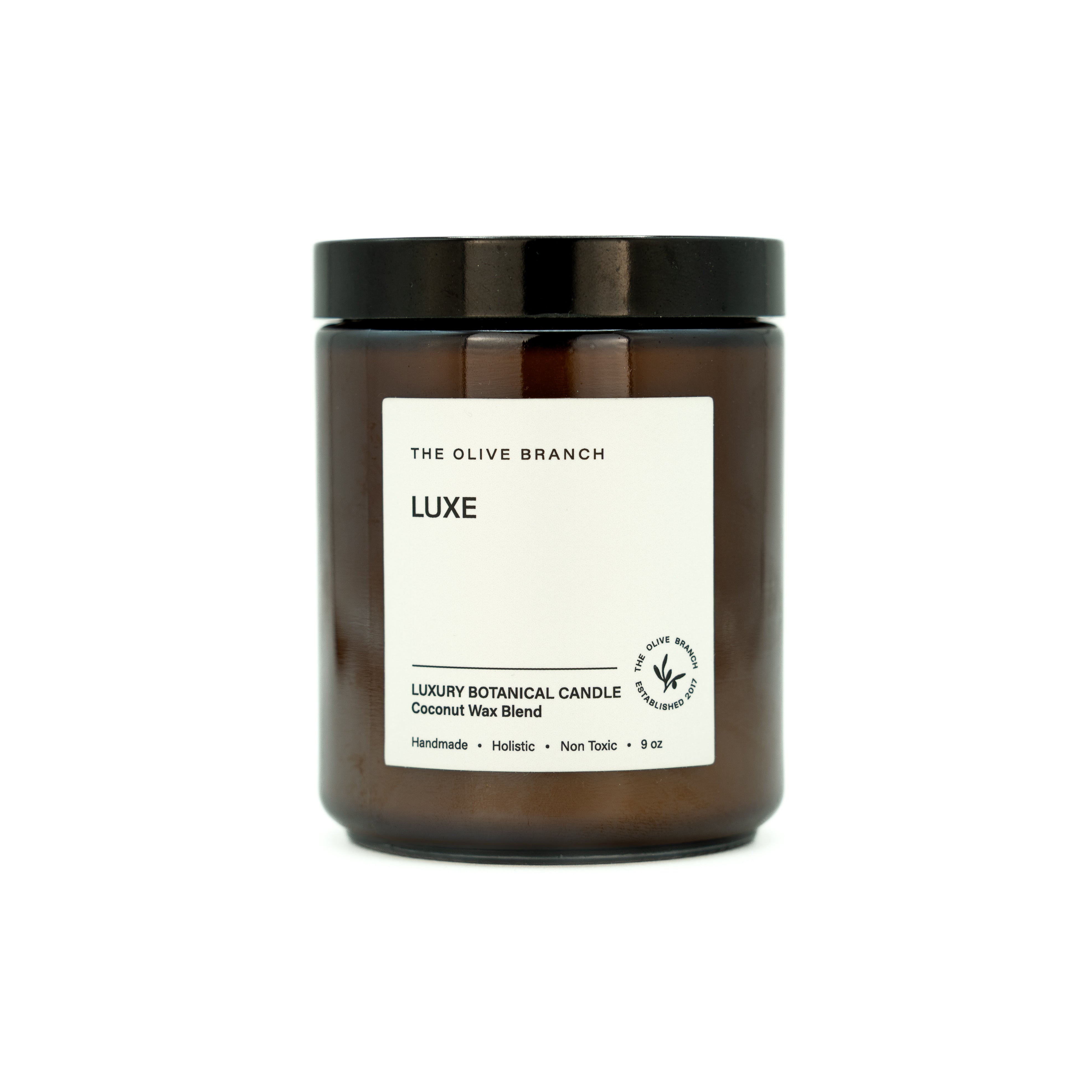 Brown candle jar with a white label for 'Luxe' on a white background