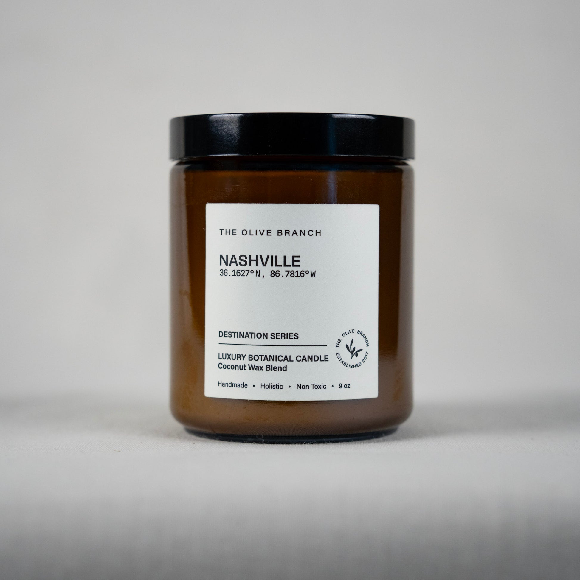 Brown candle jar 'Nashville' with black lid and white label on a gray background