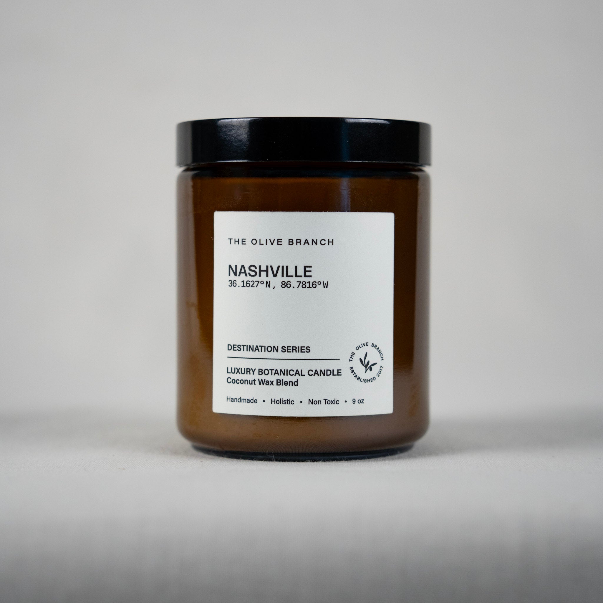 Brown candle jar 'Nashville' with black lid and white label on a gray background