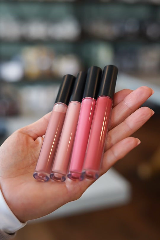 Person holding organic tinted lip conditioner's in hands.