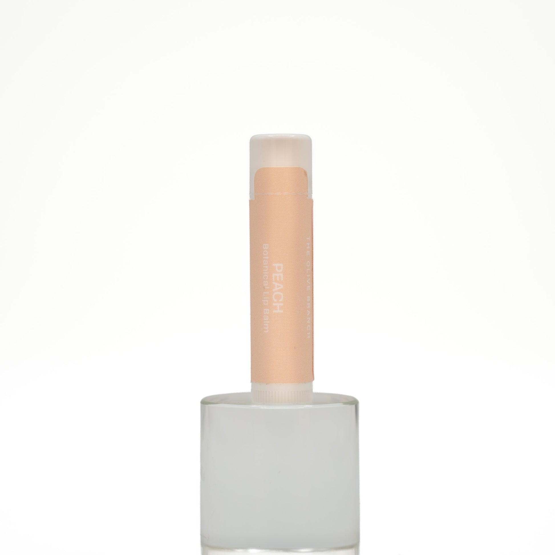 Lip balm with a white base and beige cap on a white background