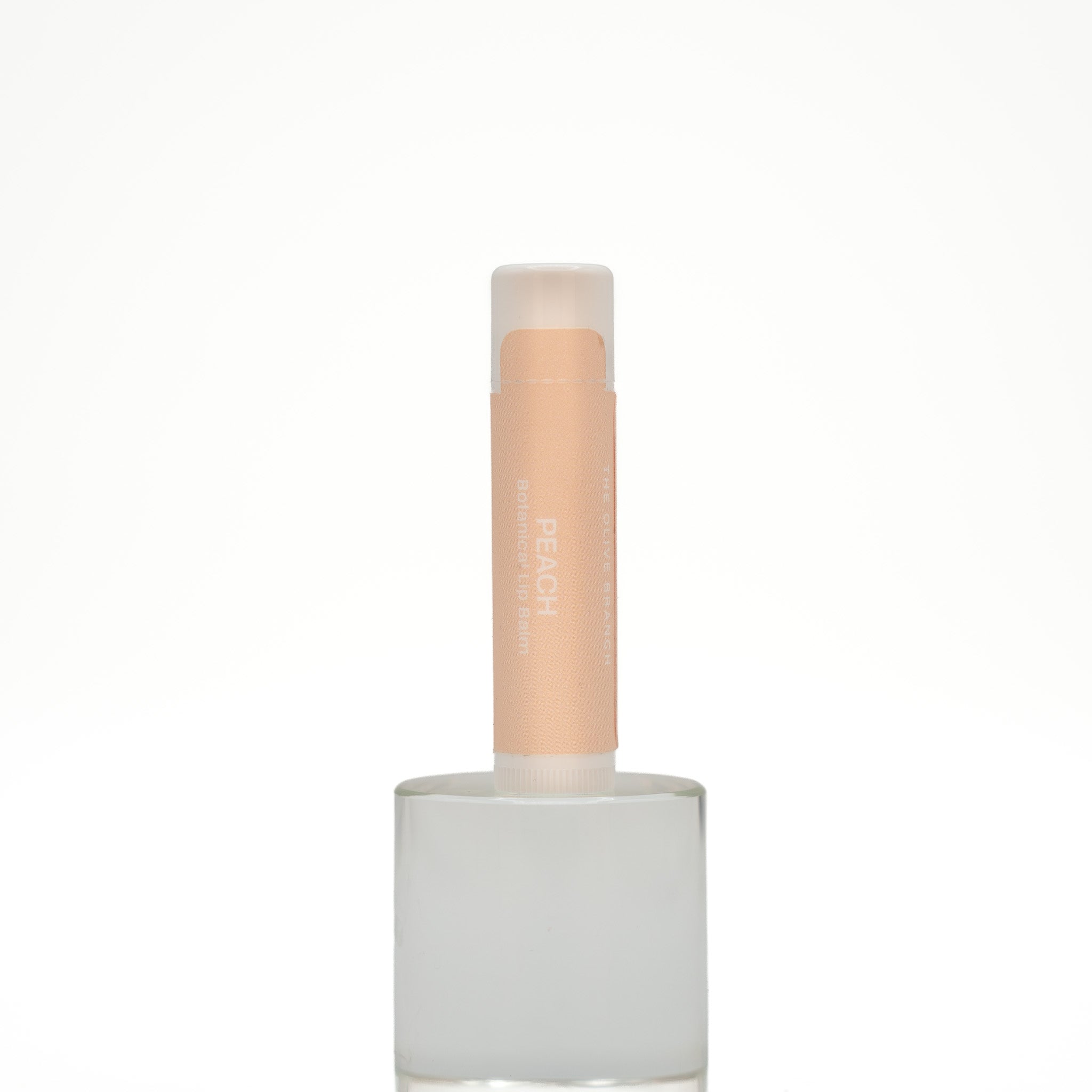 Lip balm with a white base and beige cap on a white background